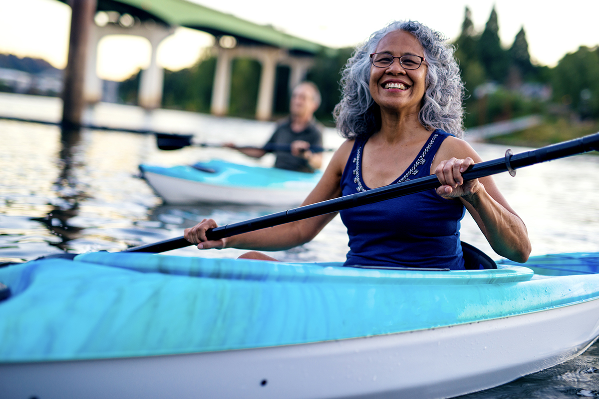 woman kayaking enjoying the success of her wealth management