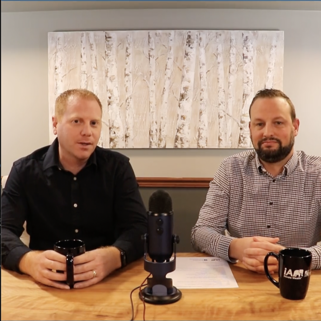 Andrew Raymer and Ryan Husk sitting at a table with a microphone in front of them discussing the Pension transfer process