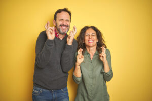 couple-with-eyes-closed-and-fingers-crossed-hoping-am-i-on-track-for-retirement